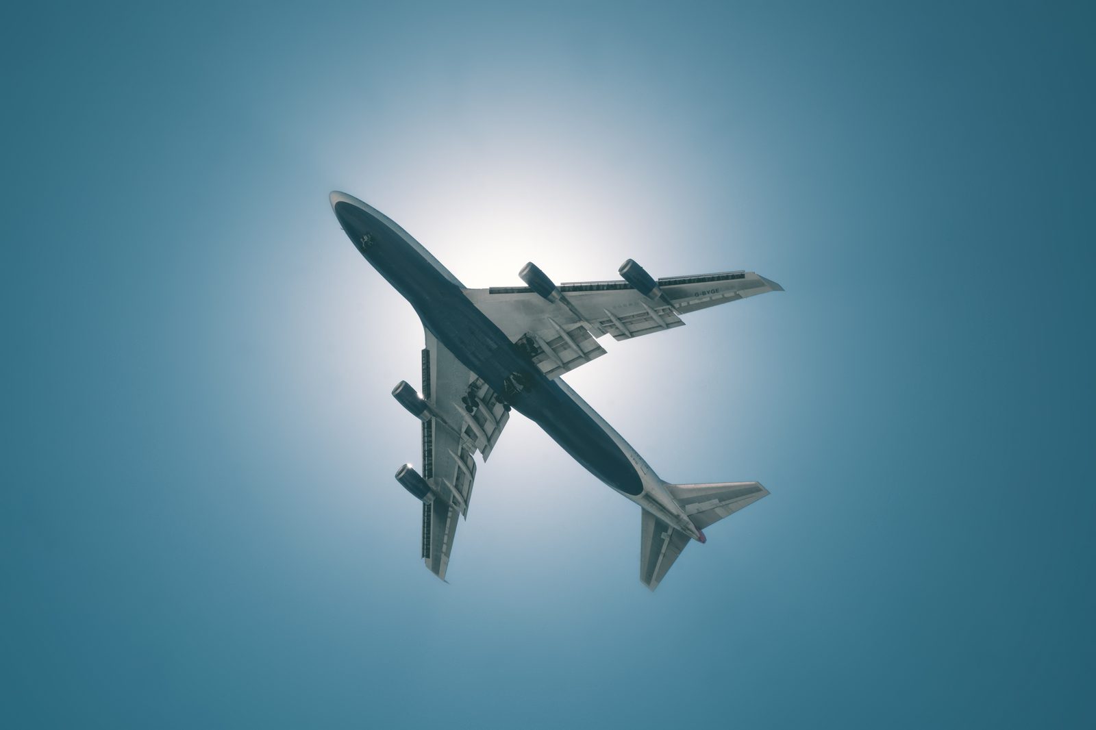 Boeing 747 freighter seen from below, backlit by the sun