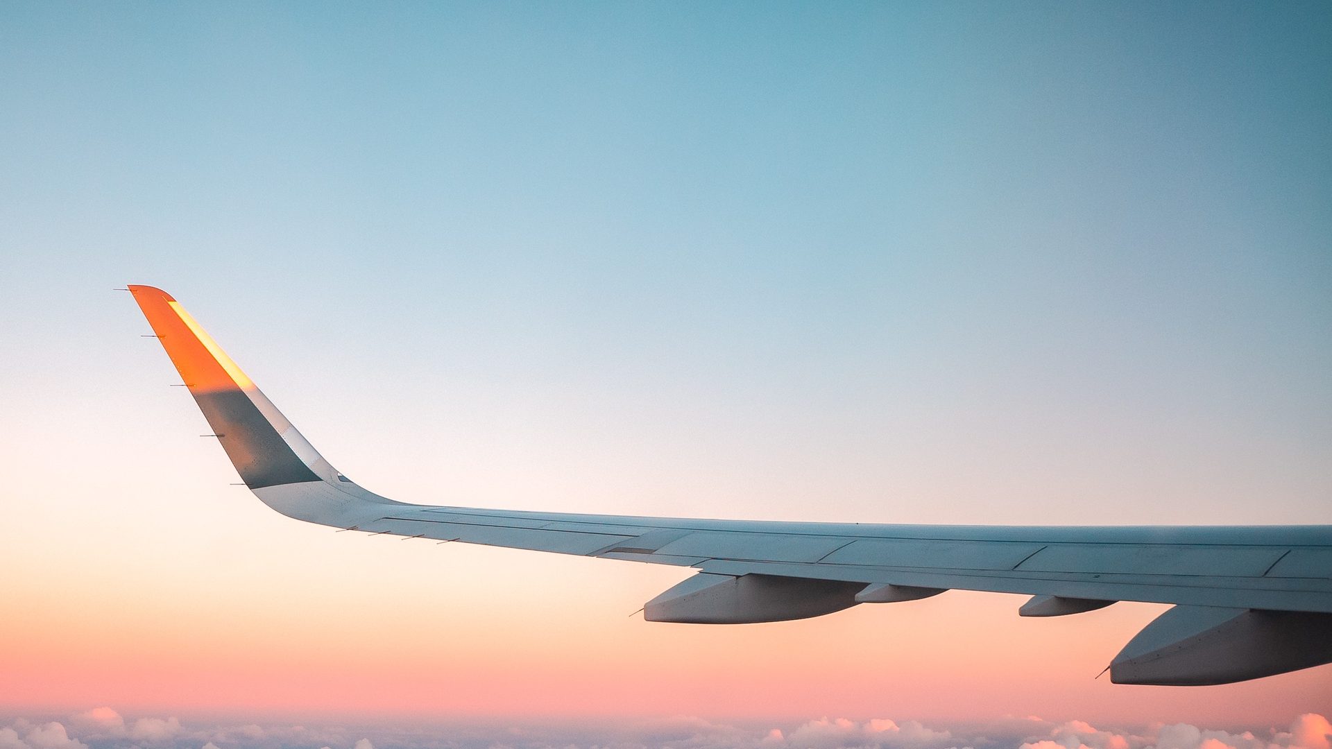 Aircraft wing above the clouds at sunset